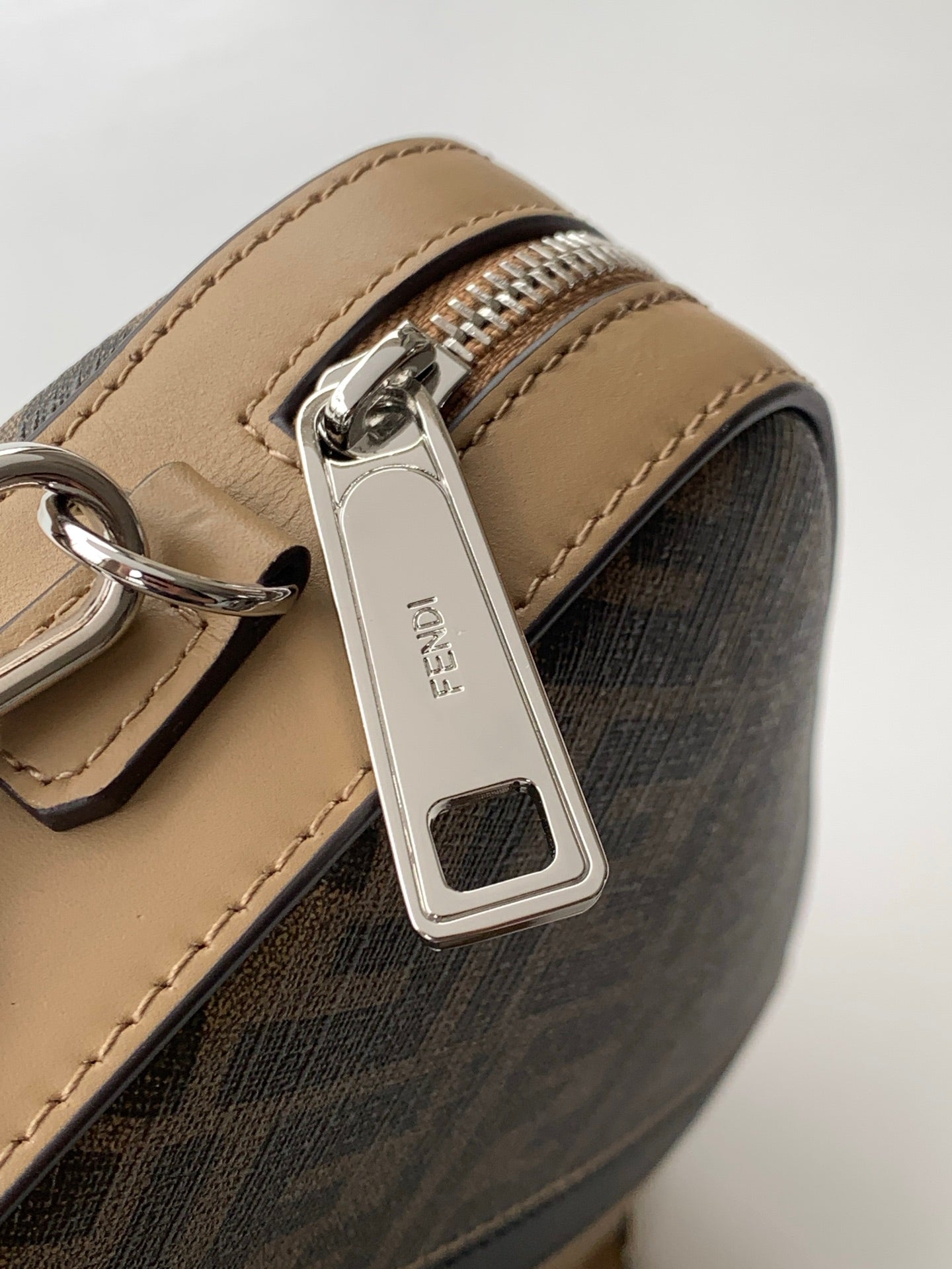 Fendi crossbody bag close-up of tan leather strap and silver clasp hardware