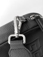 Fendi crossbody strap close-up with silver clasp and dark grained leather trim.