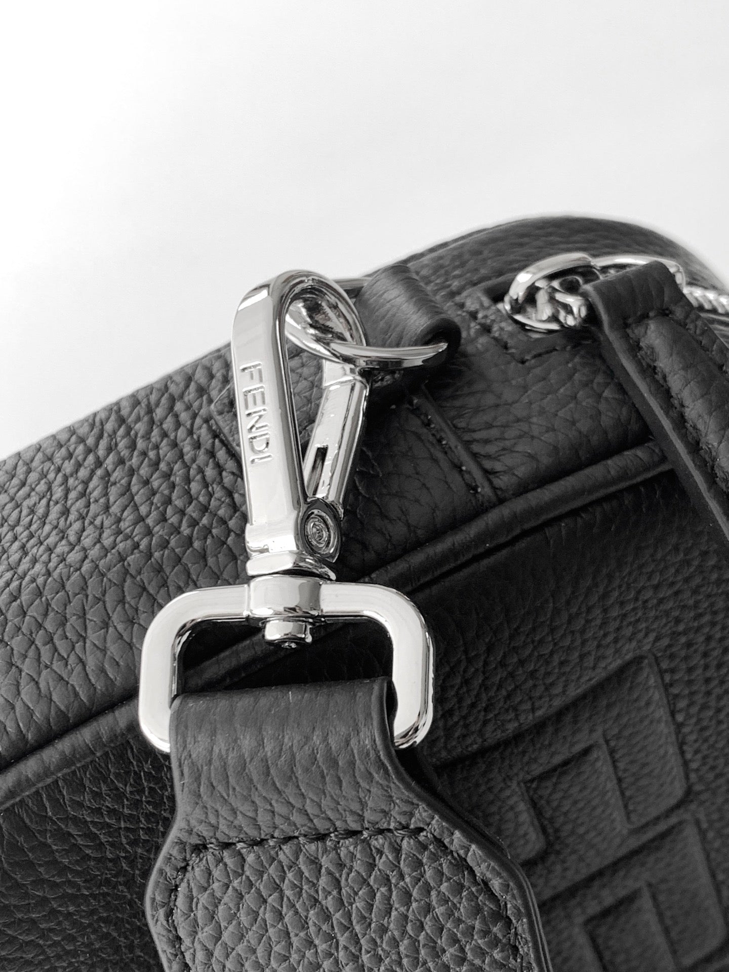 Fendi crossbody strap close-up with silver clasp and dark grained leather trim.