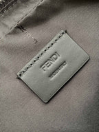 Fendi logo patch close-up on dark fabric lining with stitched edge and embossed FENDI.