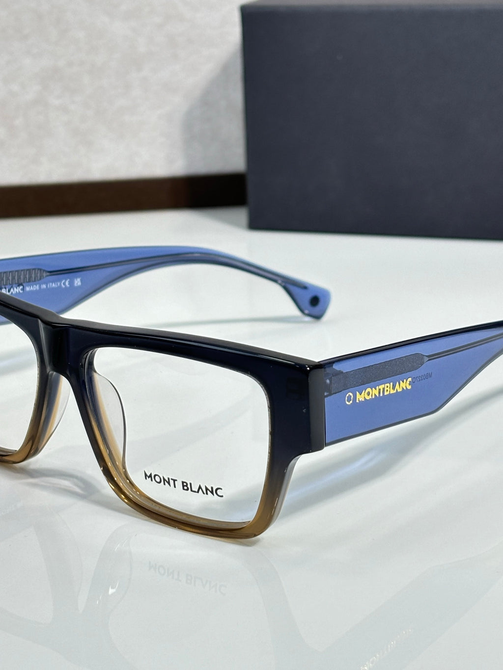 Blue and dark eyeglasses with clear lenses and Montblanc logo on side temple