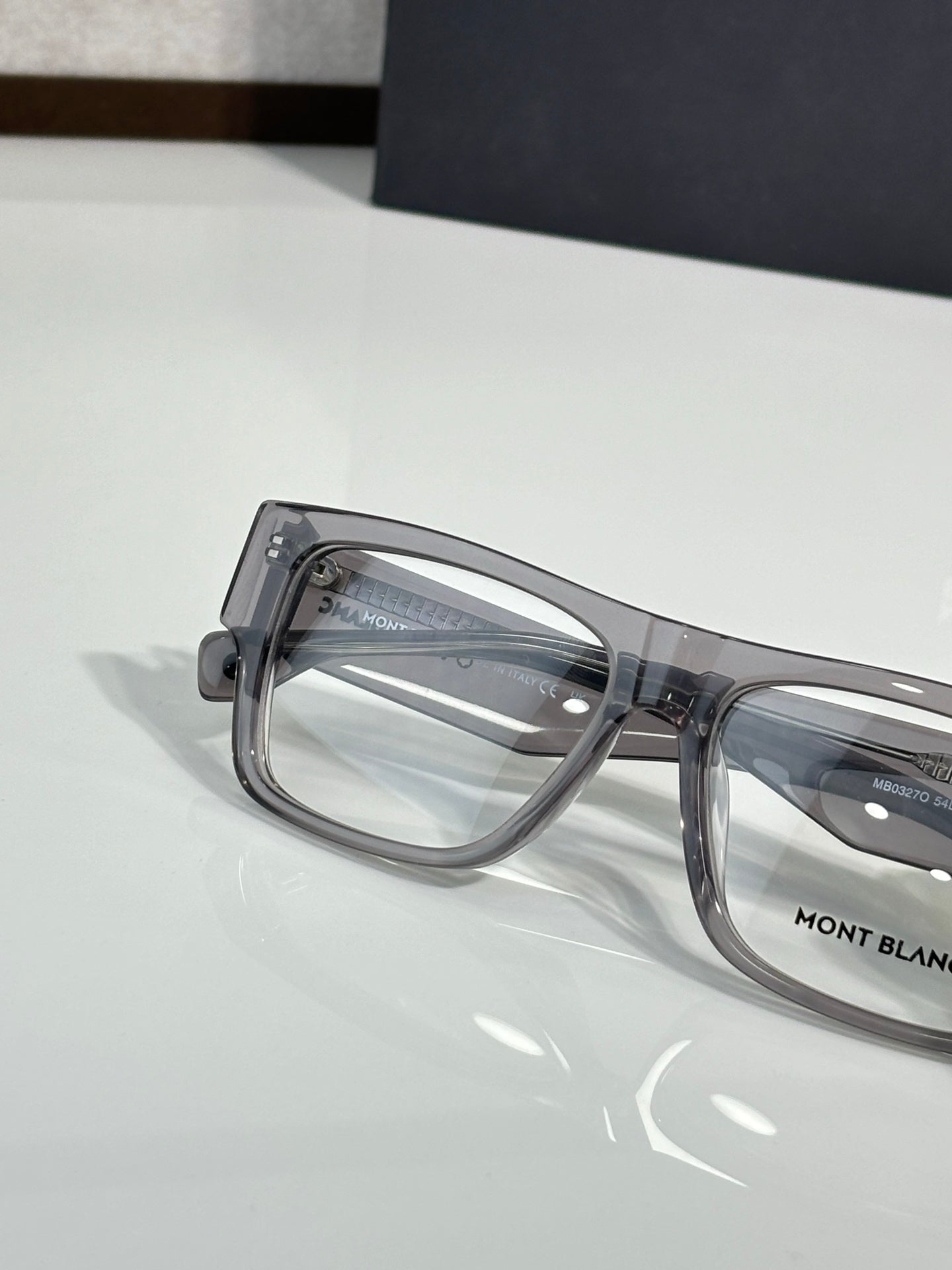 Close-up of gray full-rim eyeglasses showing clear lenses and side hinge
