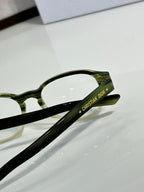 Dior eyeglasses close-up: green temple arm with logo lettering
