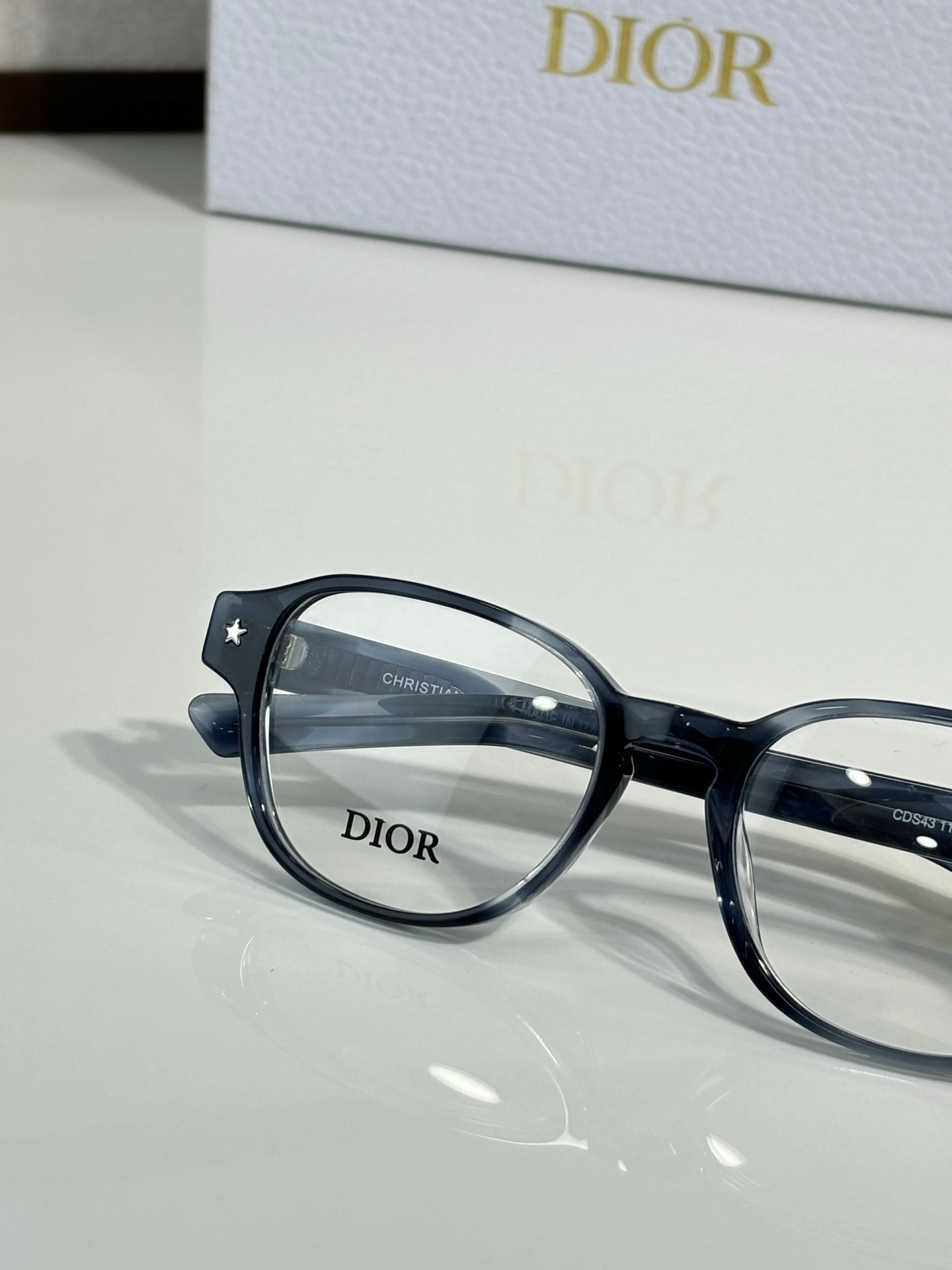 Dior eyeglasses with dark blue full-rim frames and clear lenses, close-up