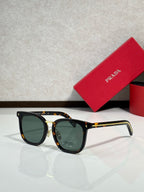 Tortoiseshell-and-gold sunglasses with greenish lenses and rounded frames.