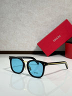 Black sunglasses with blue-tinted lenses and gold-tone bridge accents.