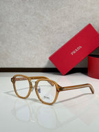 Prada eyeglasses with light tan round frames and clear lenses, logo on front.
