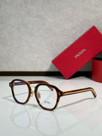 Prada eyeglasses with brown tortoise round frames and clear lenses, gold-tone temples.