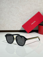 Prada black round eyeglasses with gold bridge detail and dark tinted lenses