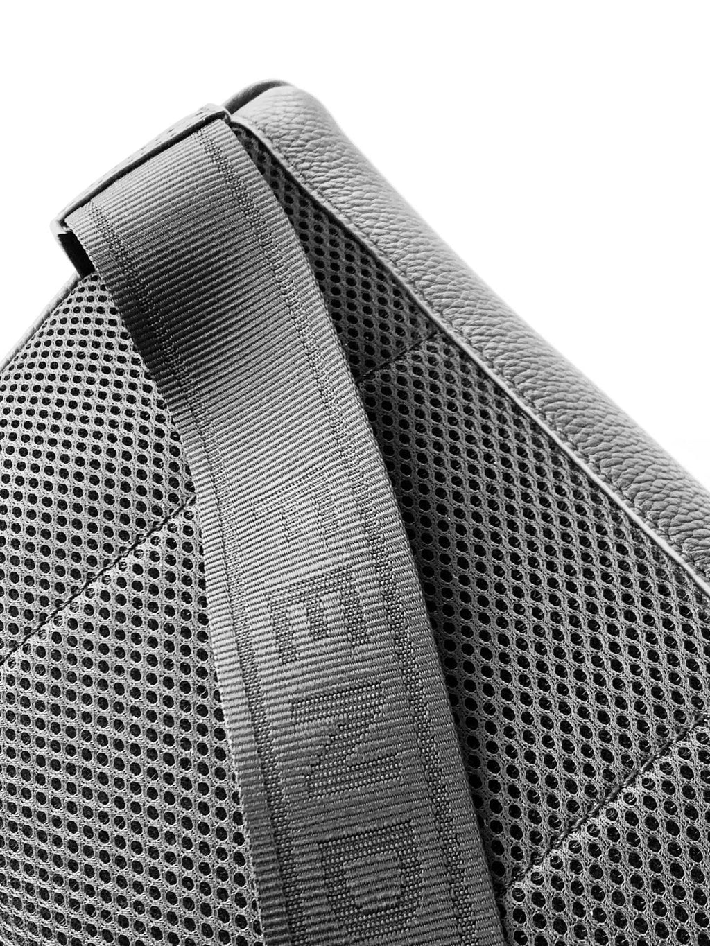 Black perforated leather strap panel with textured weave and stitch edging