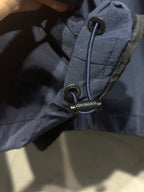 Navy hood toggle and drawcord detail on windbreaker collar