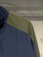 Blue jacket sleeve with contrasting green shoulder and seam trim