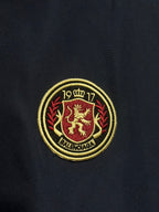 Gold and red Balenciaga crest patch on dark navy jacket fabric