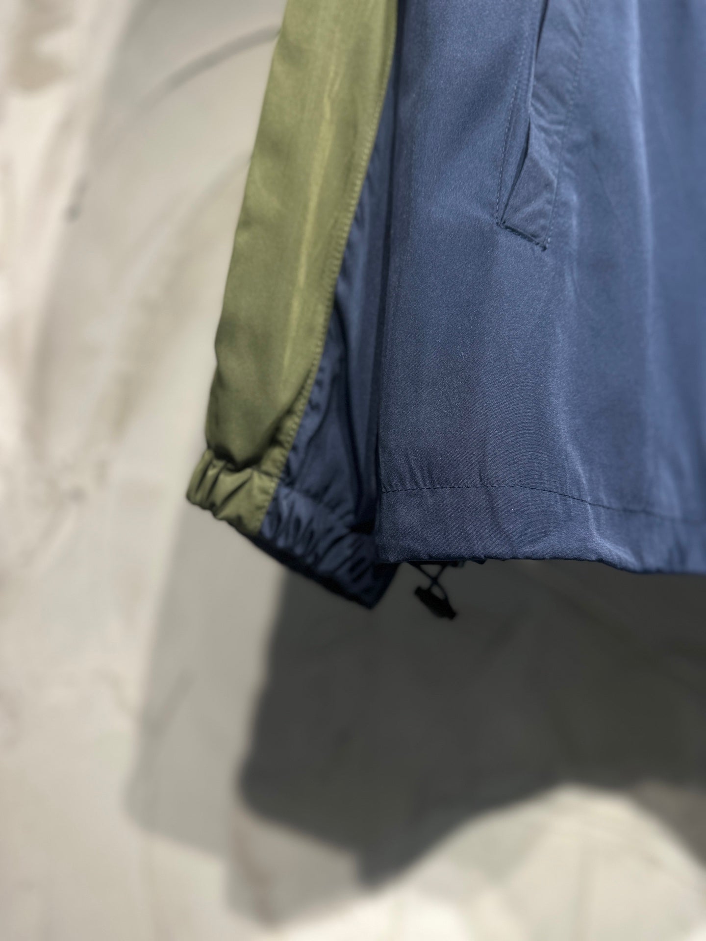 Navy jacket sleeve cuff with elastic hem and contrasting green side panel