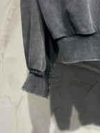 Black hoodie sleeve with ribbed cuff and visible hem stitching at bottom edge