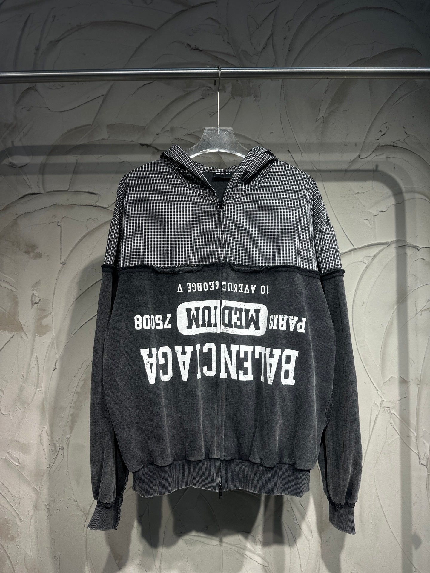 Long-sleeve hoodie with black and white check hood, black body, and large front graphic print