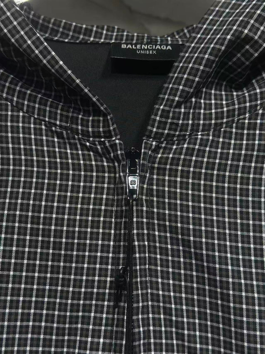 Black and white plaid zip-up hoodie with hood lining and small front zipper