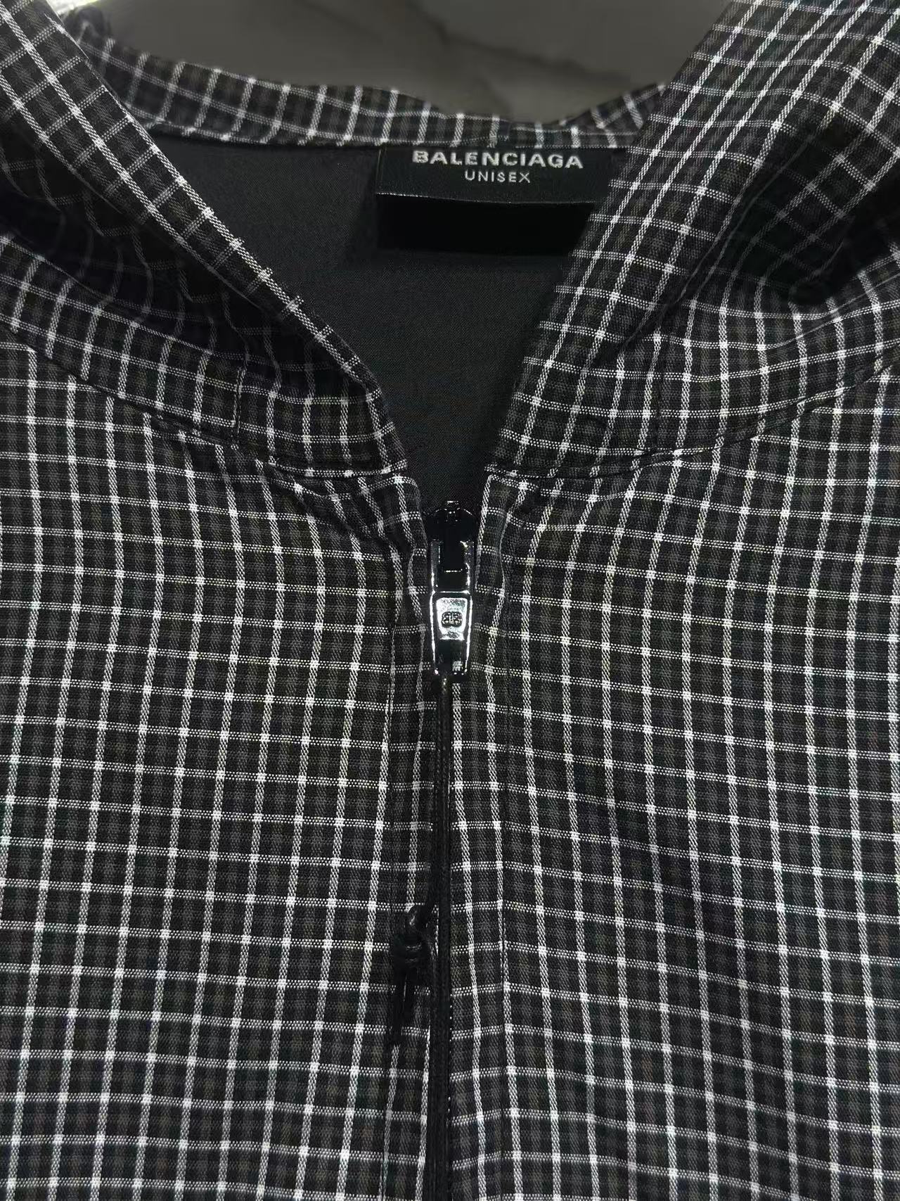 Black and white plaid zip-up hoodie with hood lining and small front zipper