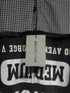 Black hoodie with large white graphic text on chest panel and hanging brand tag