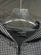 Black and white plaid zip-up hoodie, open neckline view with brand tag on collar