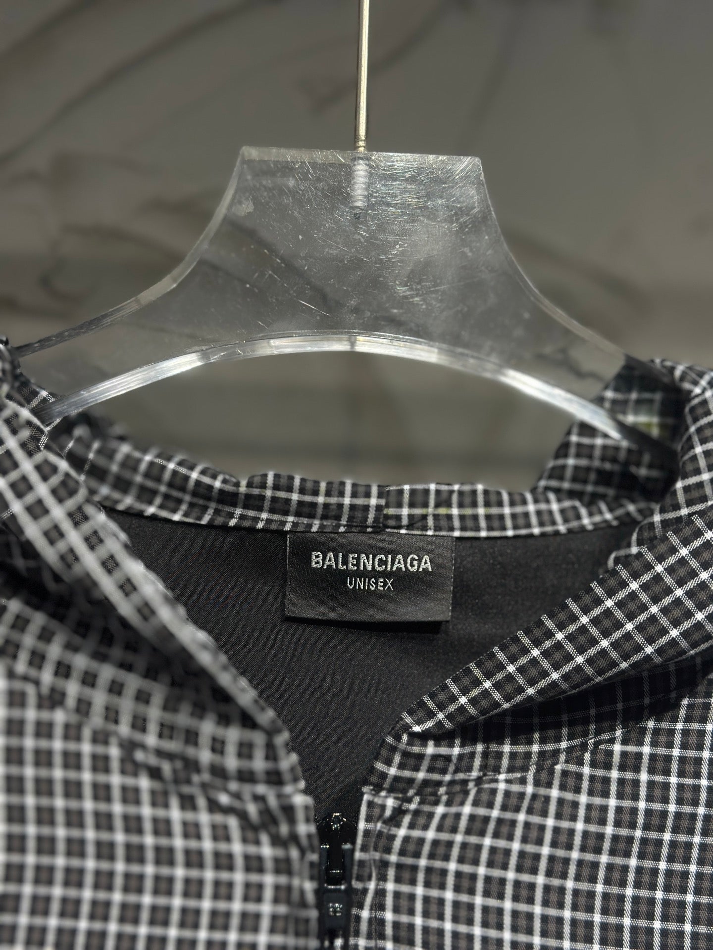Black and white plaid zip-up hoodie, open neckline view with brand tag on collar