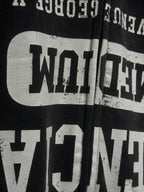 Close-up of black hoodie chest graphic with distressed white text and zipper edge