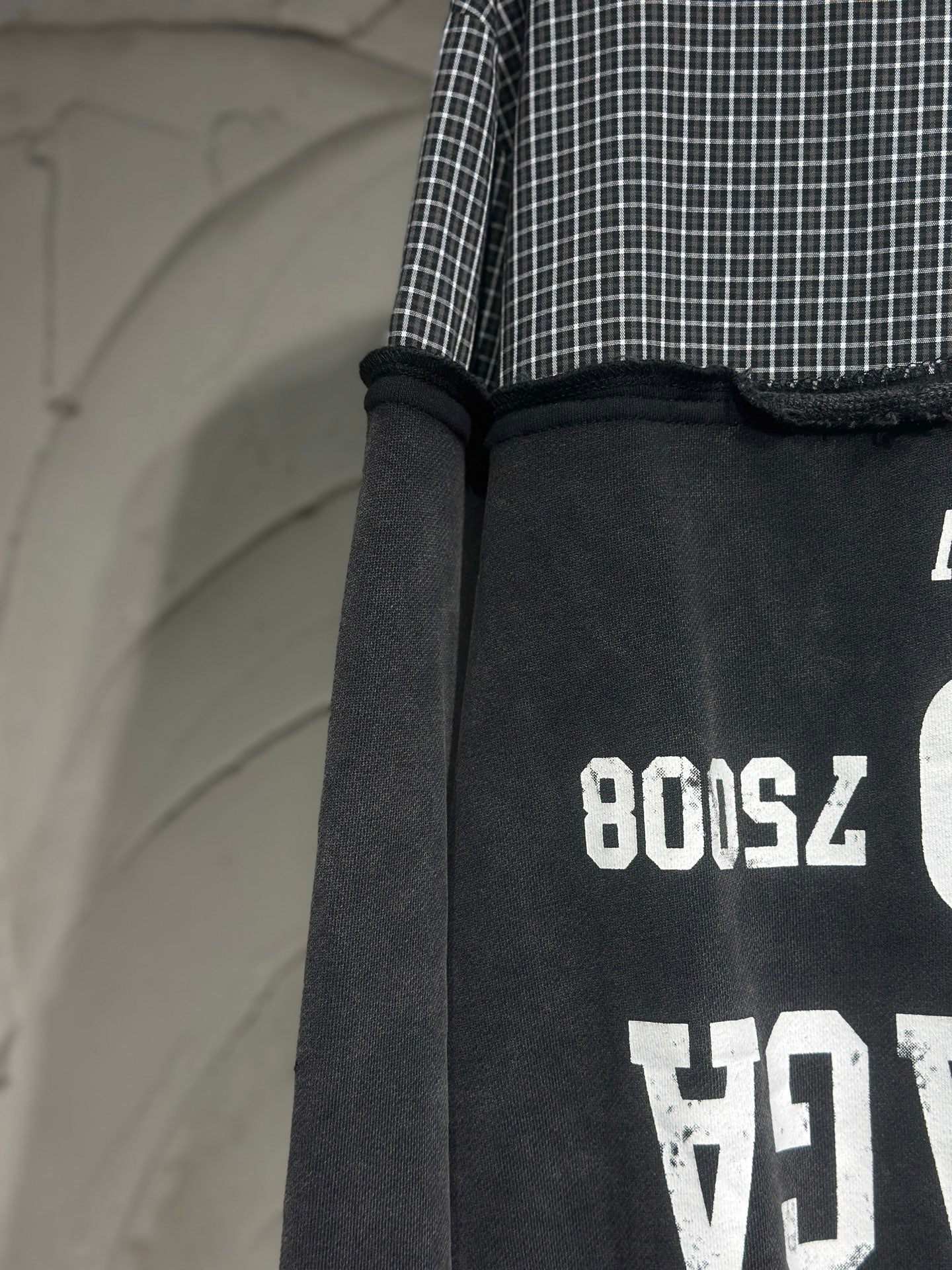 Black long-sleeve hoodie with ribbed cuff and white graphic print on sleeve
