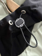 Black jacket interior with metal zipper pull and cord toggles