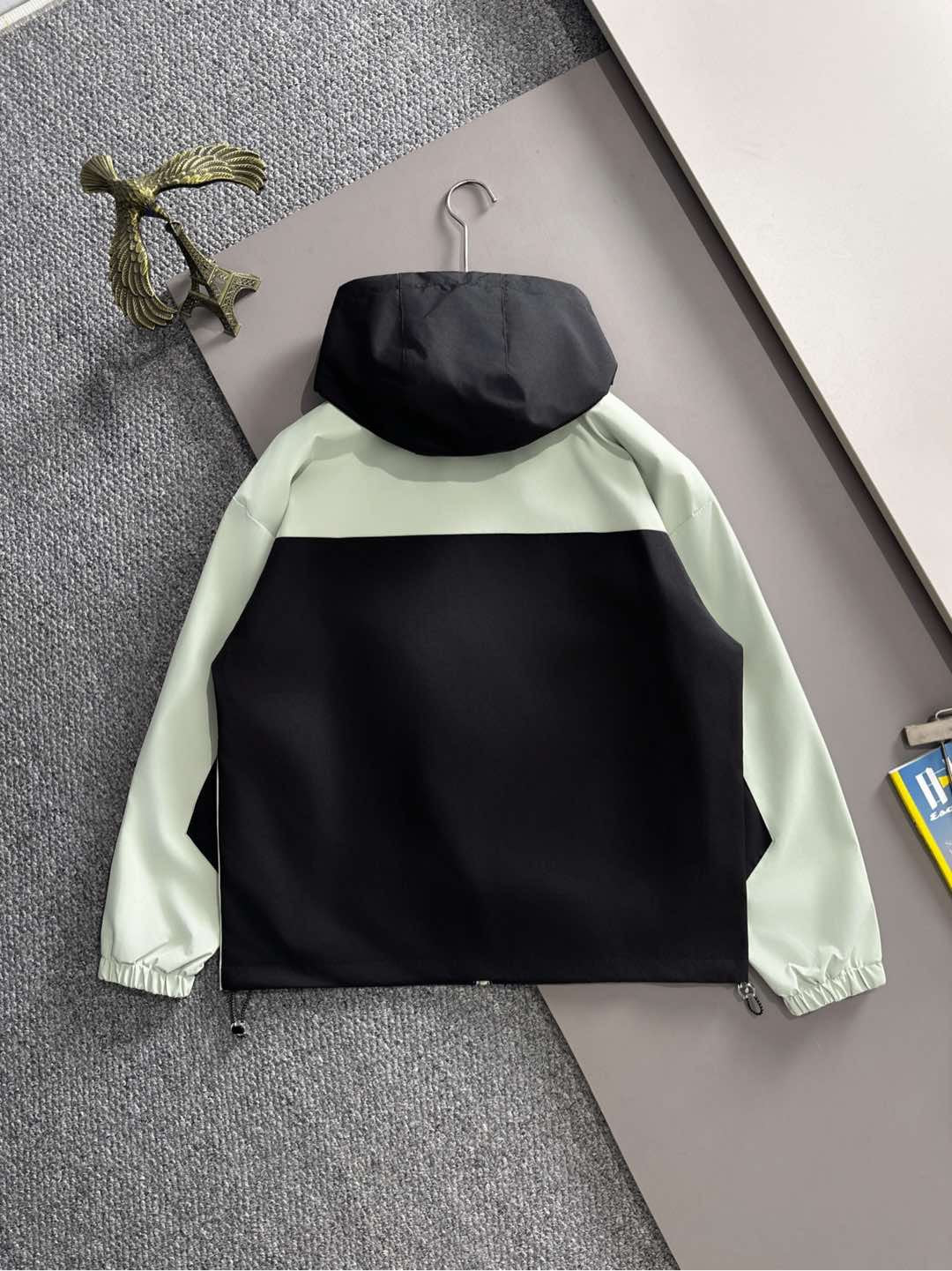 Mint and black hooded jacket with back view, front zip and drawstring hem