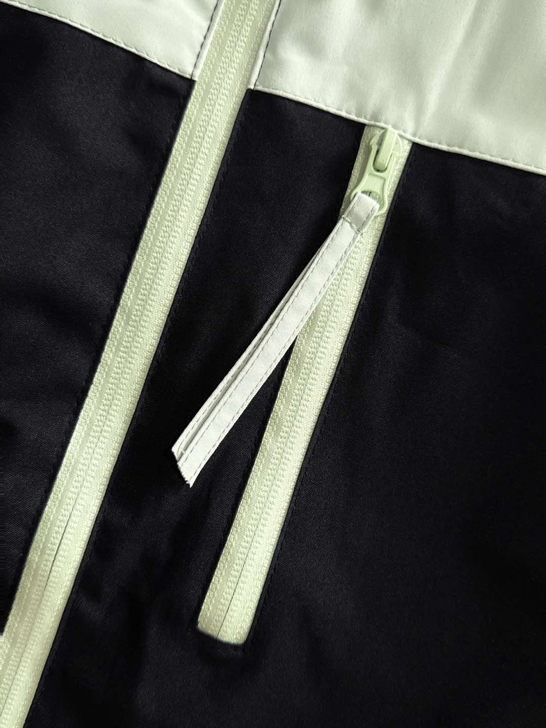 Two-tone jacket with light zipper and pull tab at center front