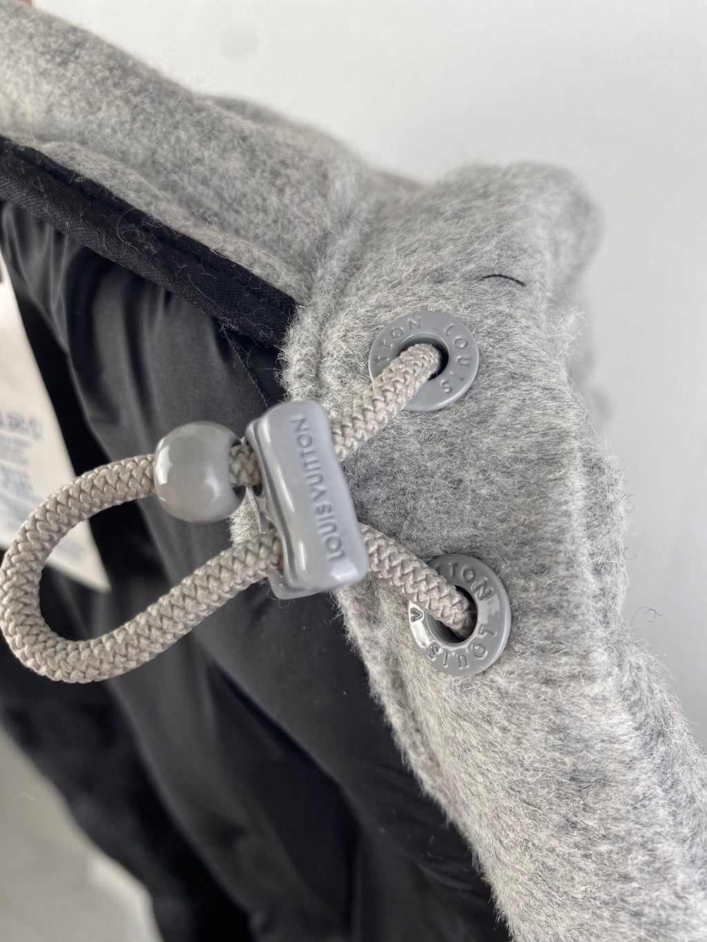 Louis Vuitton hooded jacket drawstring toggle and cord detail on gray fabric