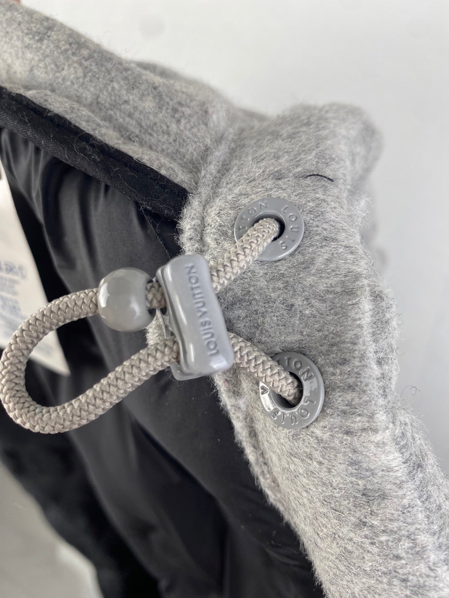 Louis Vuitton hooded jacket drawstring toggle and cord detail on gray fabric