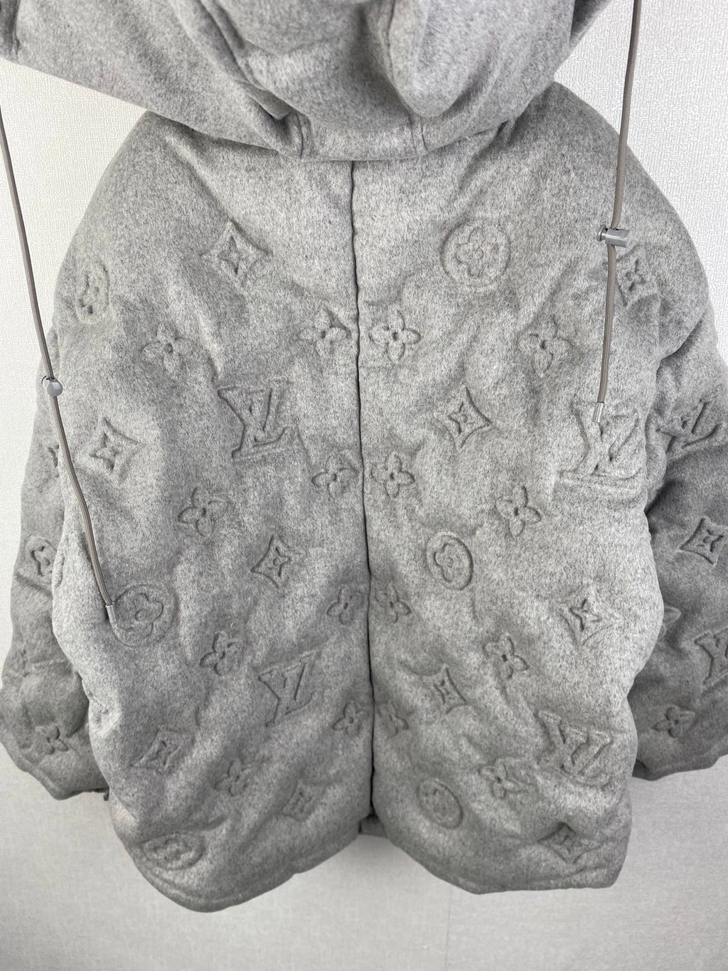 Louis Vuitton hooded puffer jacket front view, gray with allover monogram pattern