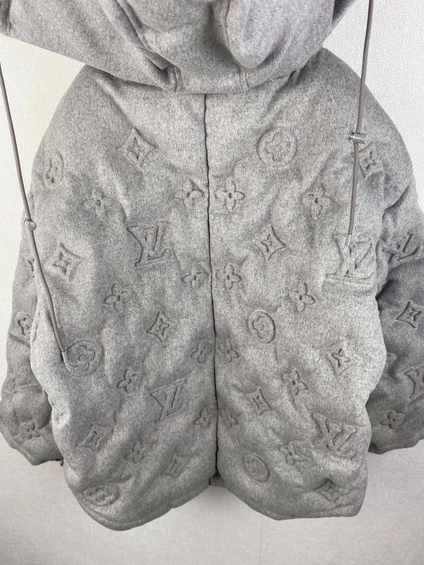 Louis Vuitton hooded puffer jacket front view, gray with allover monogram pattern