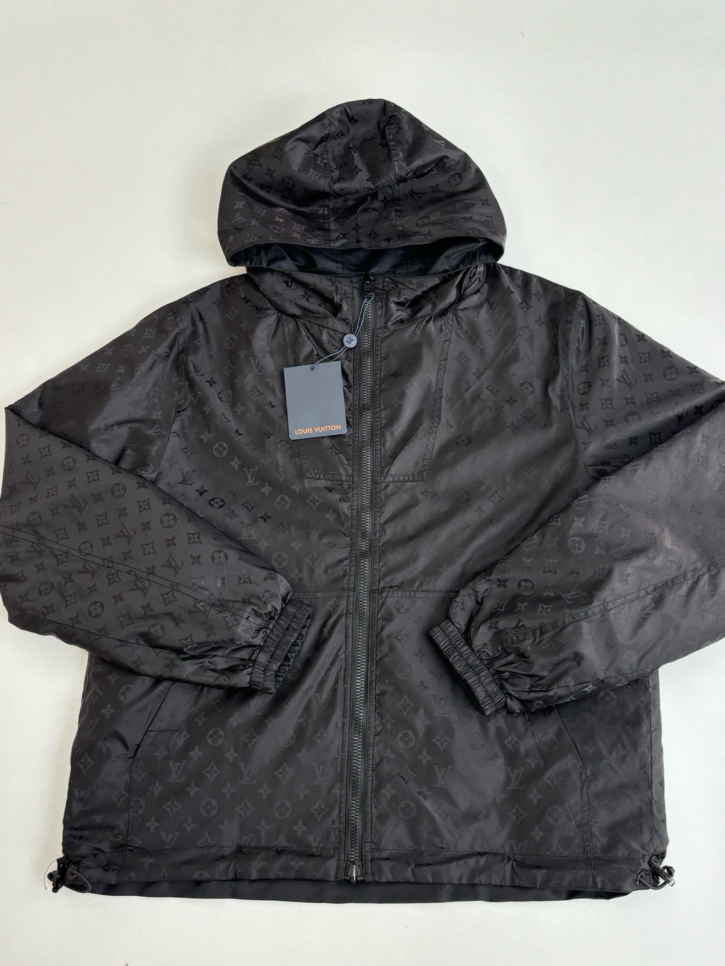 Dark navy hooded zip jacket with monogram-style pattern, front close-up