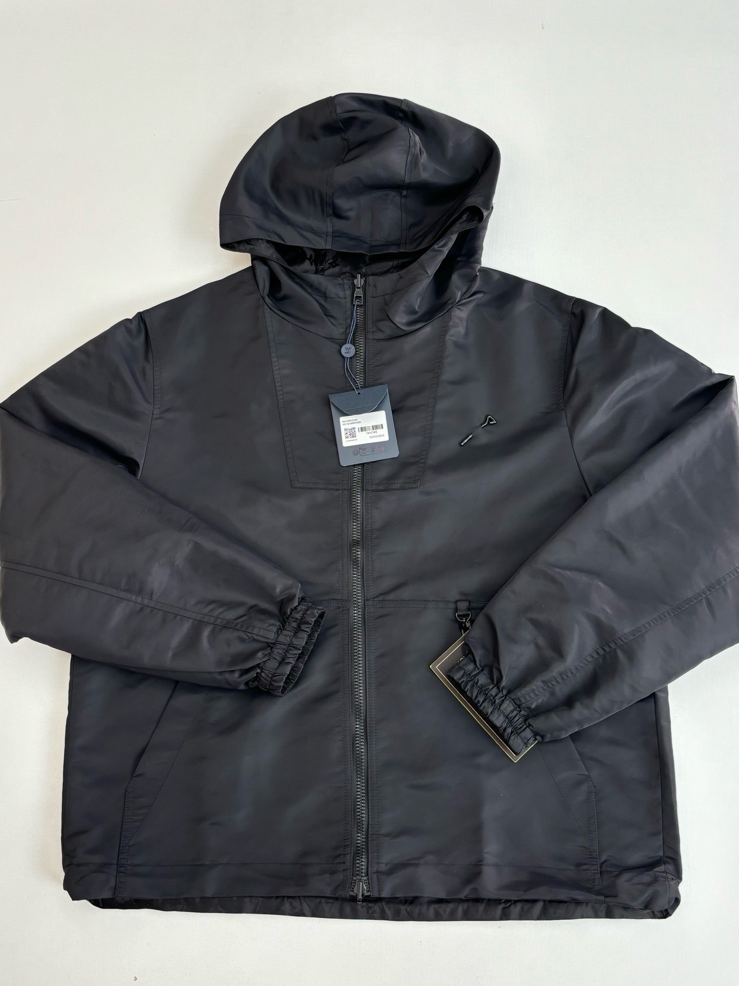 Dark navy hooded zip jacket with side pockets and elastic cuffs, front close-up