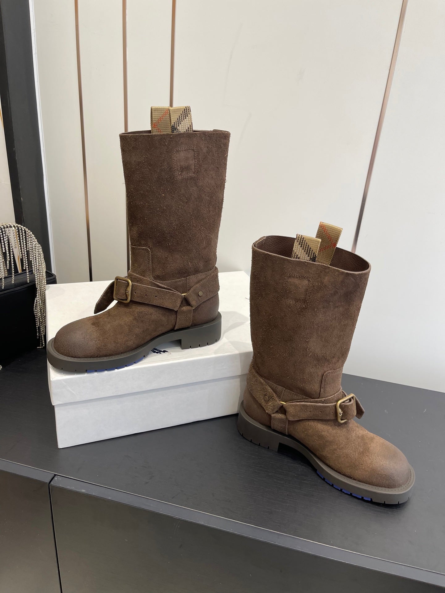 Dark brown suede tall boots with side buckle straps and cushioned cuff opening