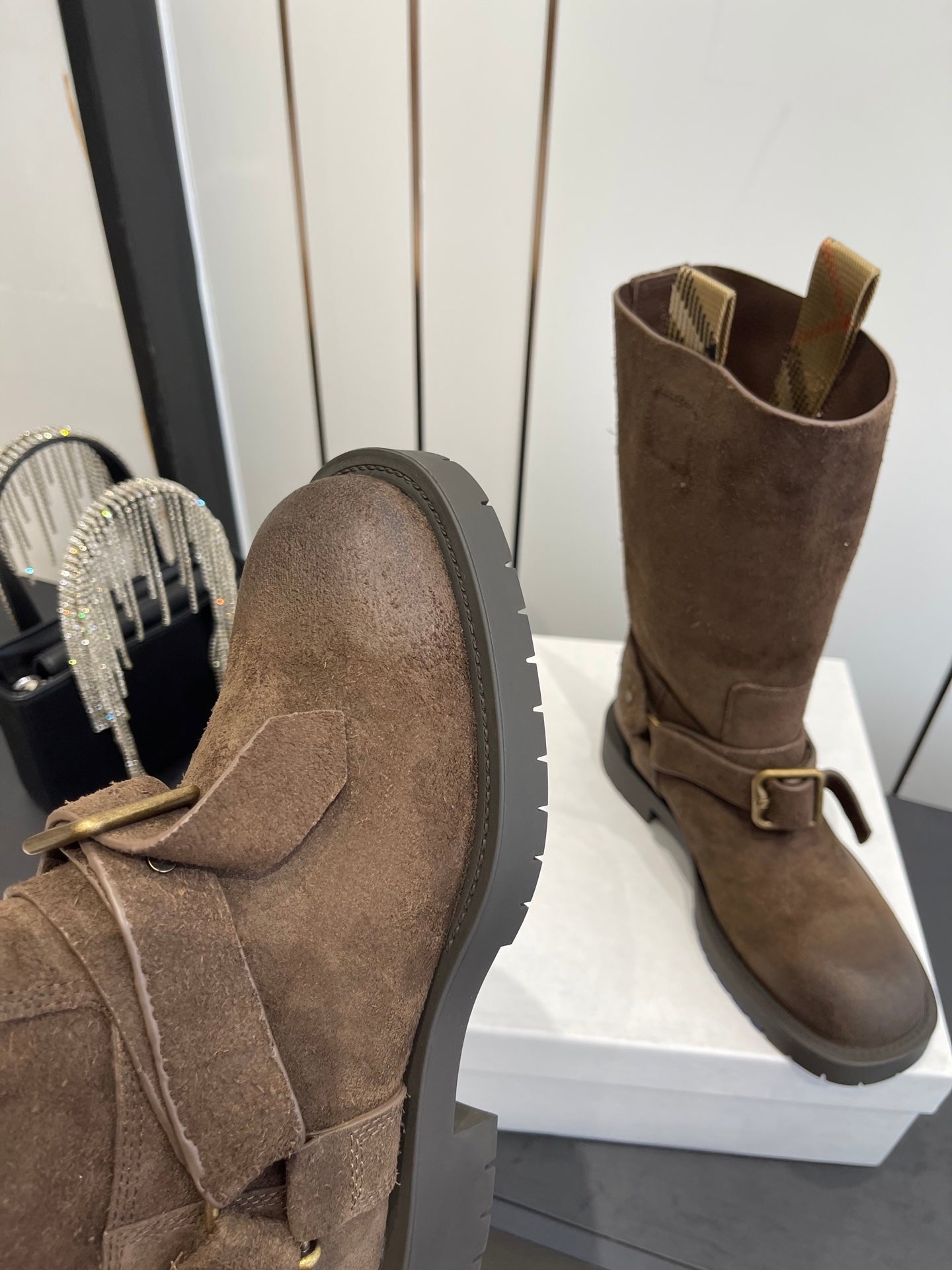 Dark brown suede boots with side buckle strap and thick lug-style sole