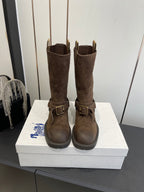 Dark brown suede tall boots with side buckle straps and low-profile rubber sole