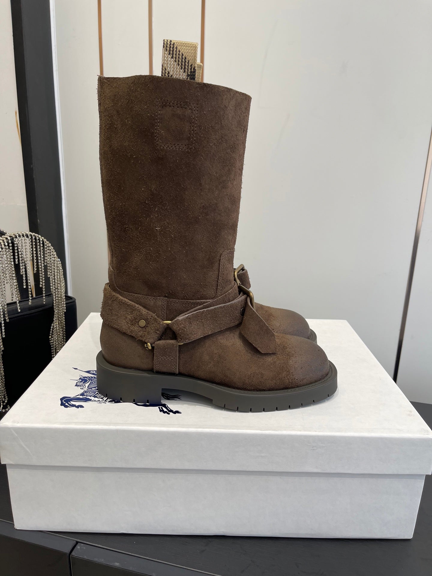 Dark brown suede mid-calf boots with wide side buckle strap and textured sole