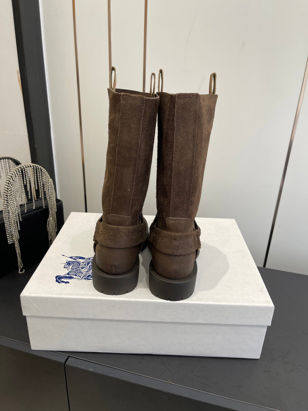 Dark brown suede tall boots viewed from the back with pull tabs and low heel