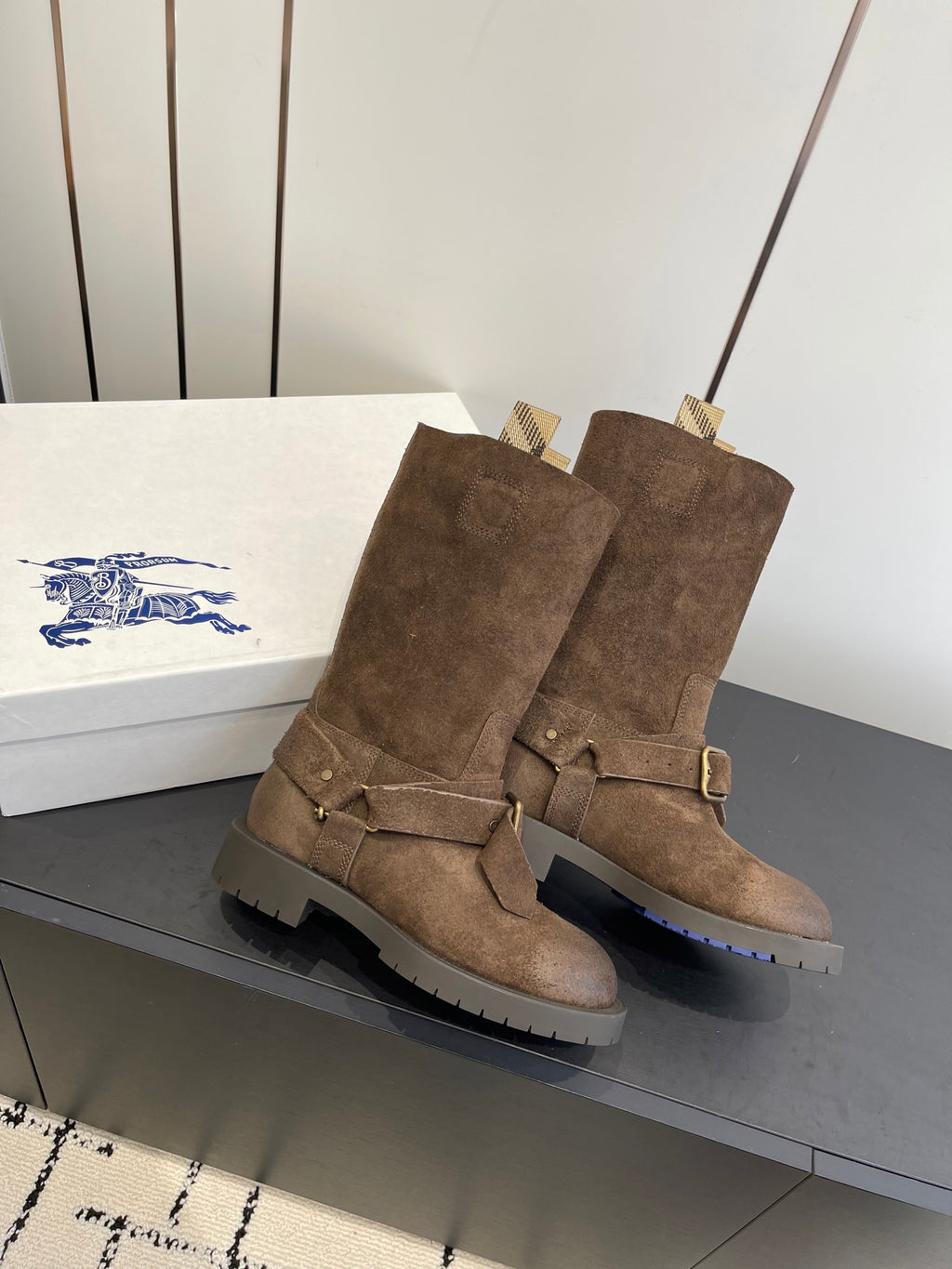 Dark brown suede boots with side buckle straps and chunky lug soles, angled view