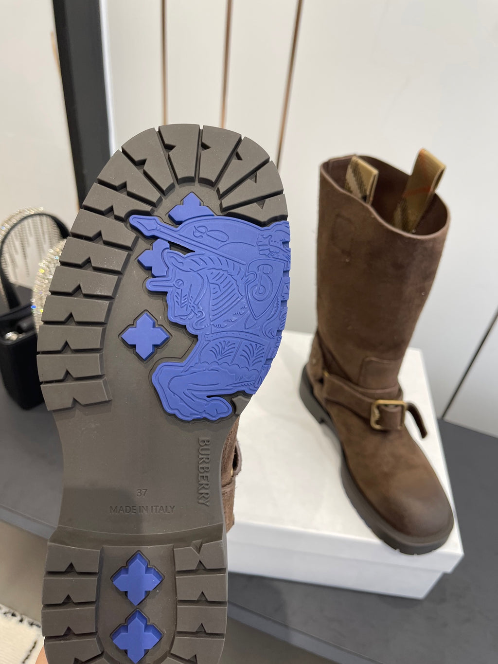 Boot outsole with blue tread pattern and dark brown upper, side view