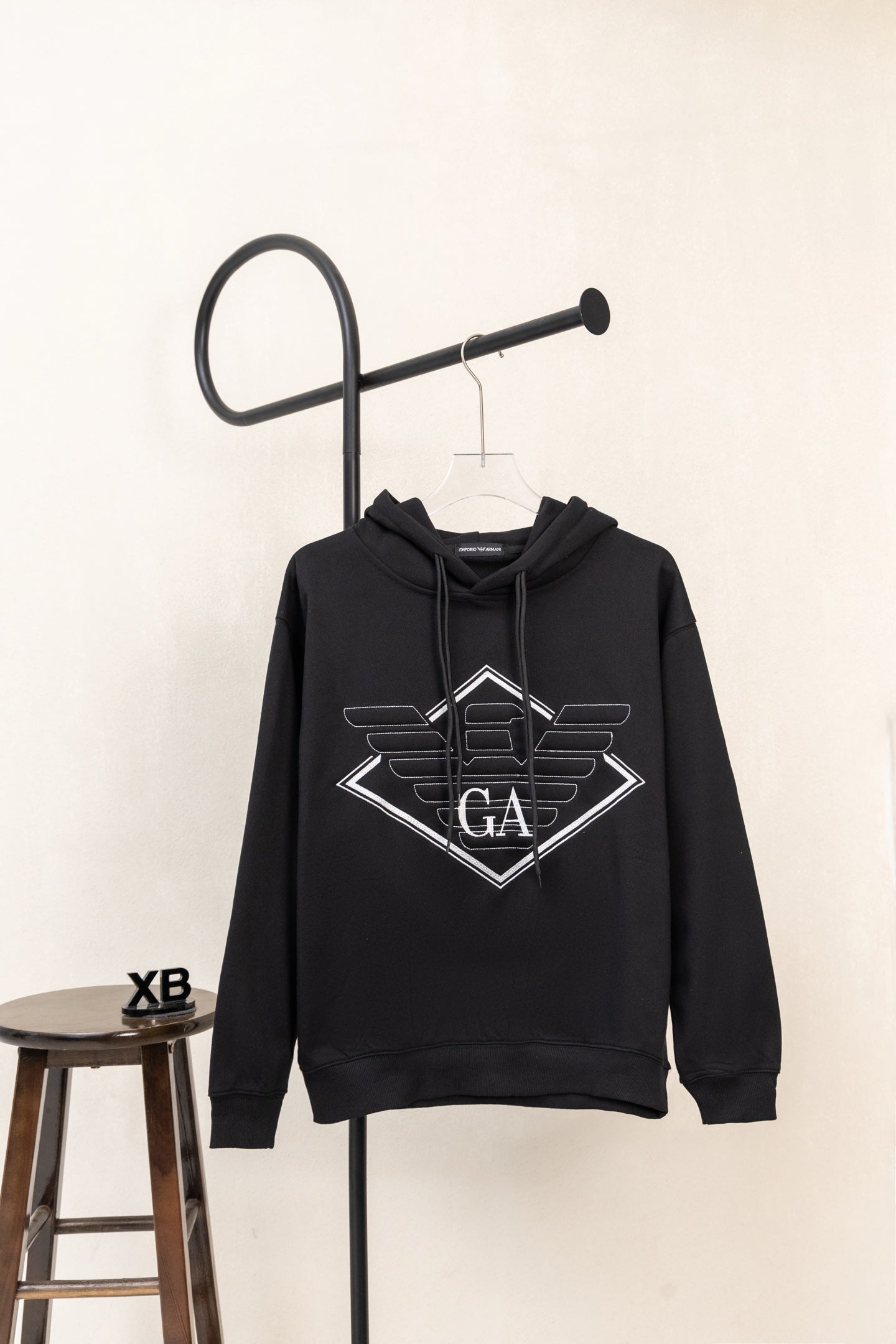 Black pullover hoodie with large chest logo print and drawstring hood