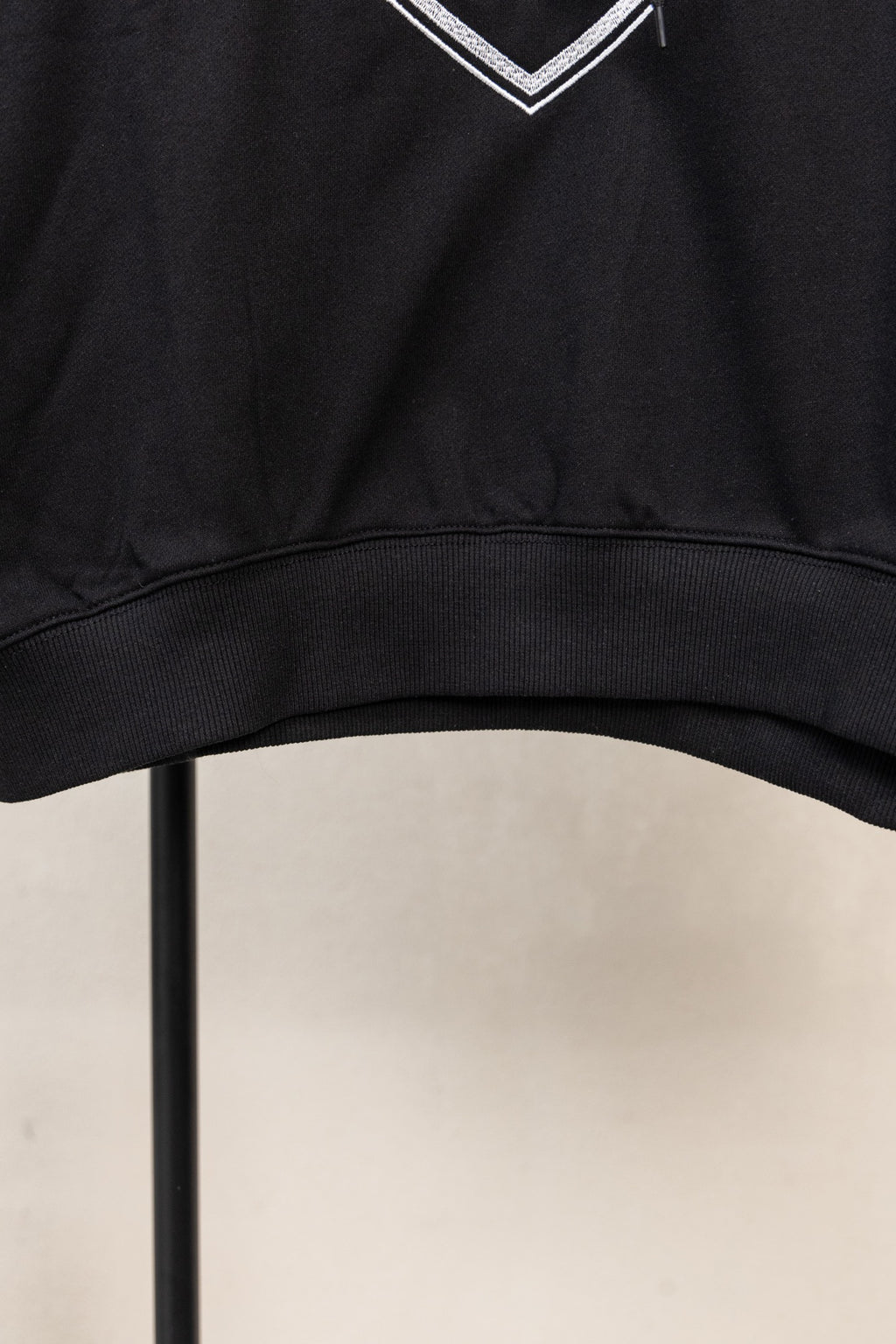 Black hoodie hem with ribbed trim and bottom edge