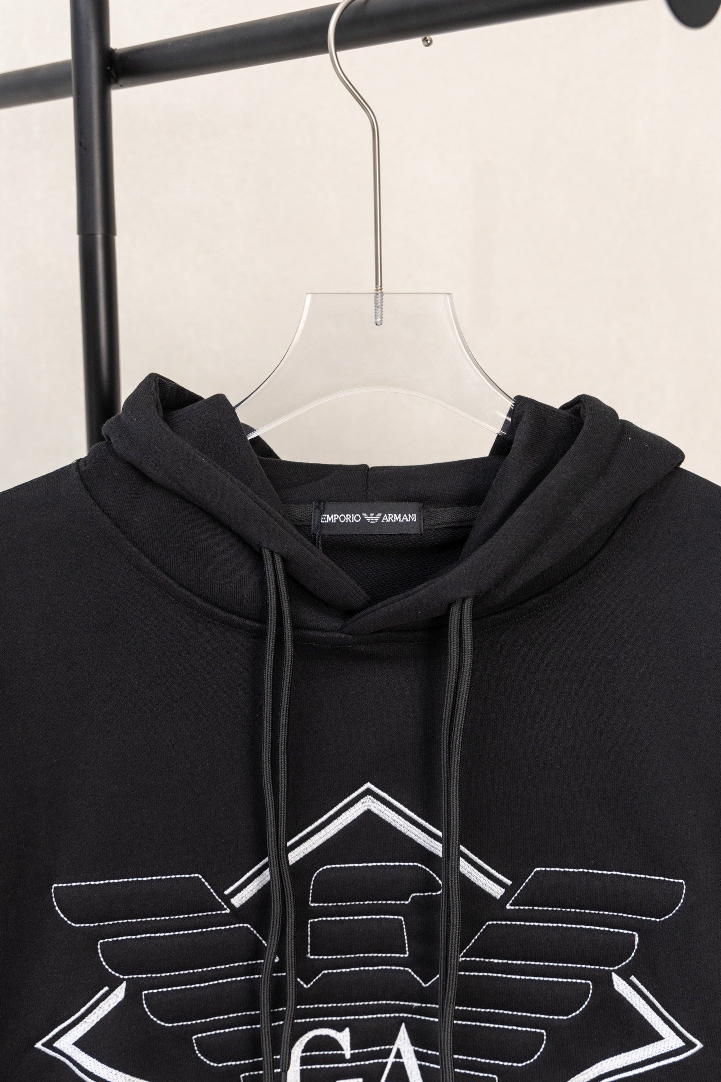 Black hoodie hood with drawstrings and large front logo graphic