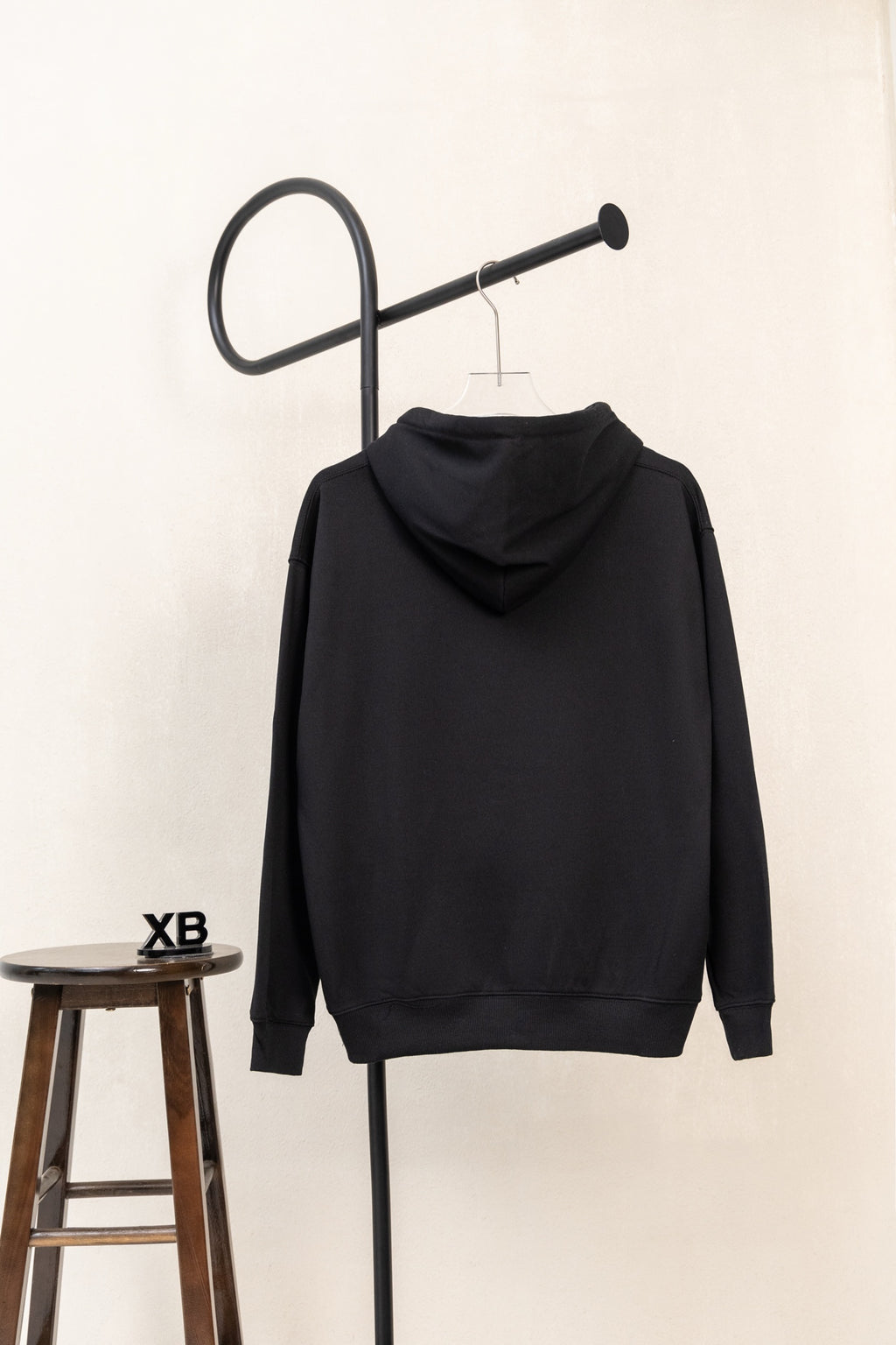 Black pullover hoodie with hood and long sleeves, back view