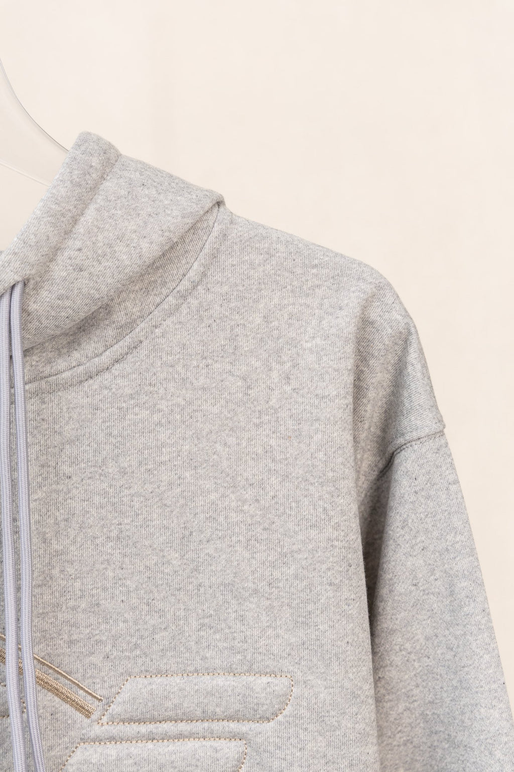 Amiri hoodie side view in light gray heather with ribbed hem and smooth fabric
