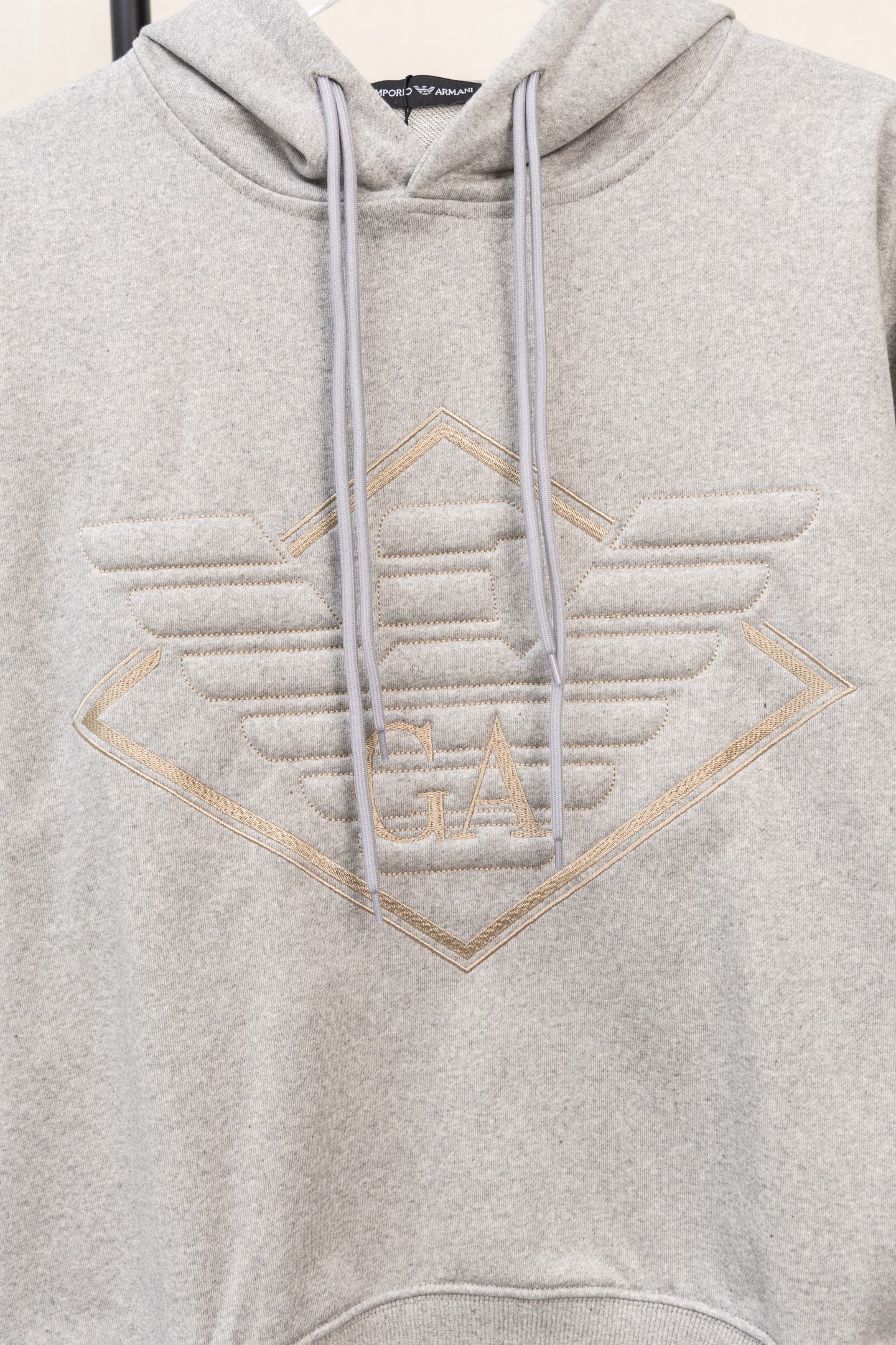Amiri hoodie in light gray heather with embroidered V logo and drawstring hood