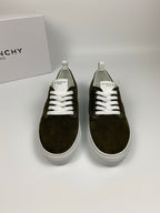Pair of olive suede sneakers with white laces, white soles, and Givenchy logo at tongue.